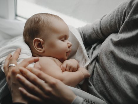 Charming newborn boy sleeps on mother's arms