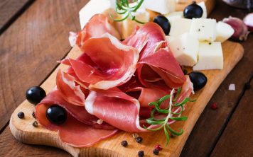 Meat appetizer on a plate on old wooden background